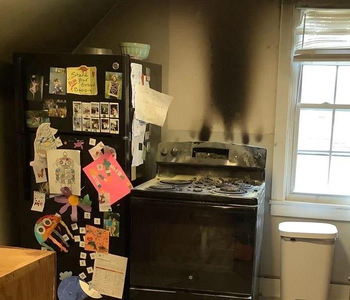 damaged black kitchen stove with black smoke on walls and ceiling