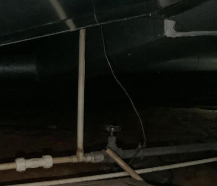 crawlspace with white pipes